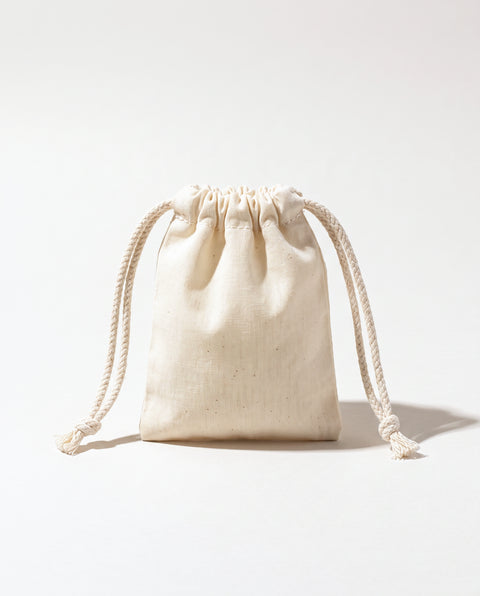 Plain natural cotton muslin double drawstring bag with braided cotton cords, white background