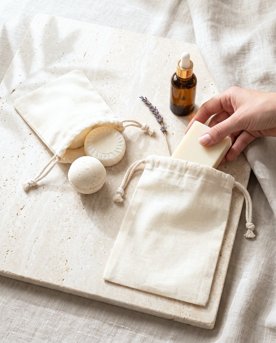 Natural cotton muslin drawstring bags in use for soaps, bath bombs and serums