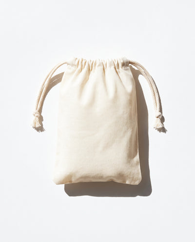 Plain natural cotton muslin double drawstring bag with braided cotton cords, white background